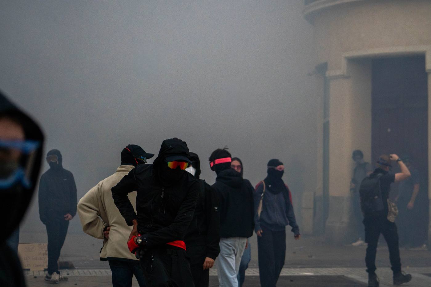 Silhouettes de manifestants dans la fumée des gaz lacrymogènes
