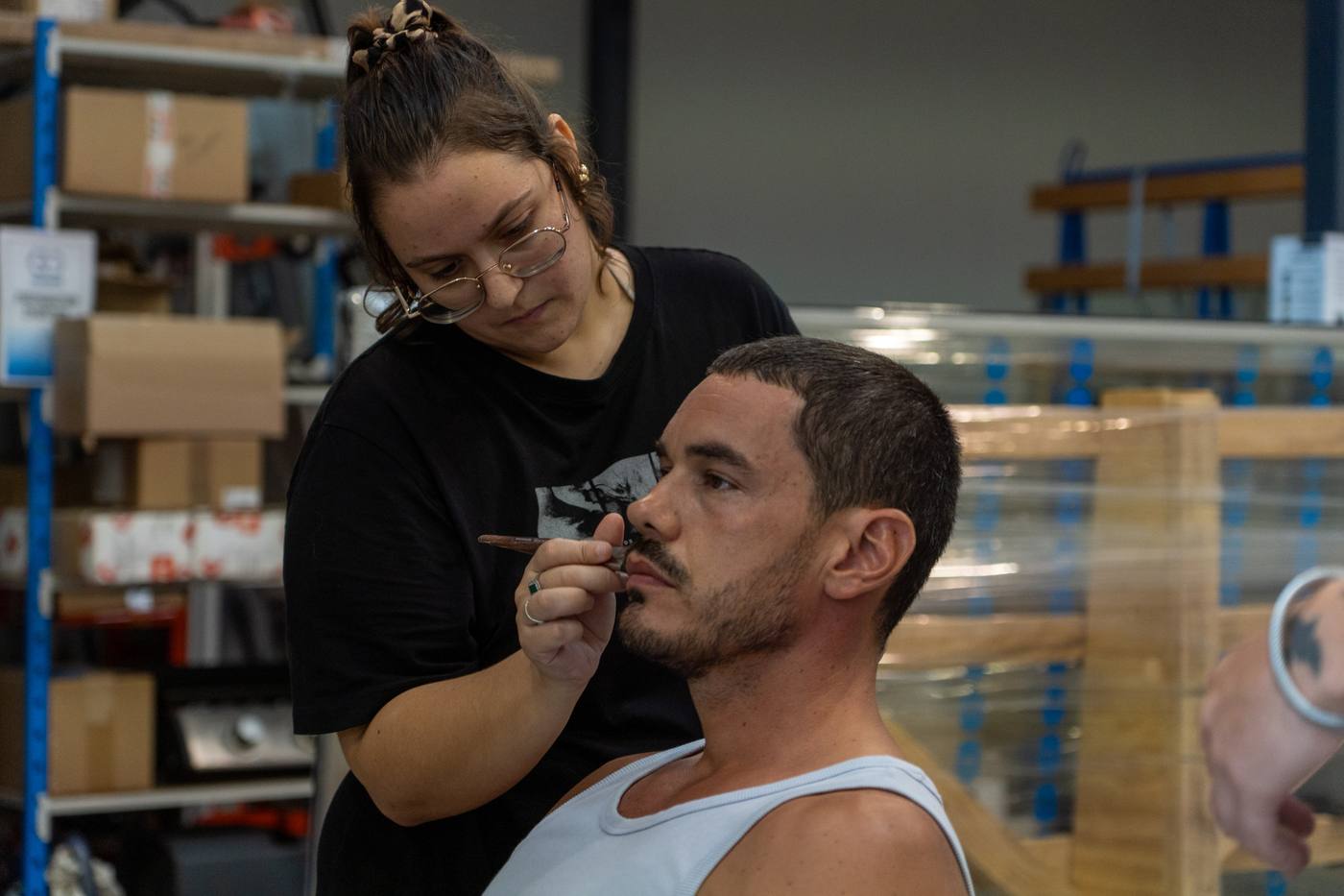 Maquillage d’un comédien dans un entrepôt